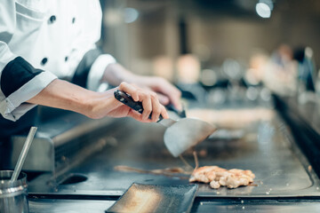 Hand of man take cooking of meat with vegetable grill, Chef cooking wagyu beef in Japanese teppanyaki restaurant