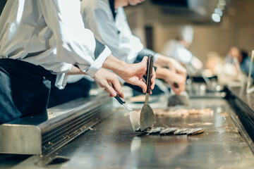 Hand of man take cooking of meat with vegetable grill, Chef cooking wagyu beef in Japanese teppanyaki restaurant
