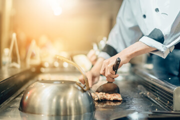 Hand of man take cooking of meat with vegetable grill, Chef cooking wagyu beef in Japanese teppanyaki restaurant