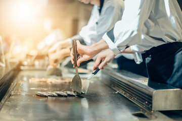 Hand of man take cooking of meat with vegetable grill, Chef cooking wagyu beef in Japanese teppanyaki restaurant