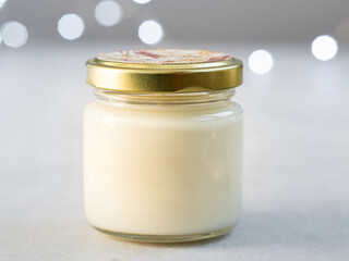 White candle on gray background with bokeh lights. Christmas concept. Copy space. Simple minimalism concept. Candle flame at night with bokeh. Abstract blurred background. Place for text, copy space.