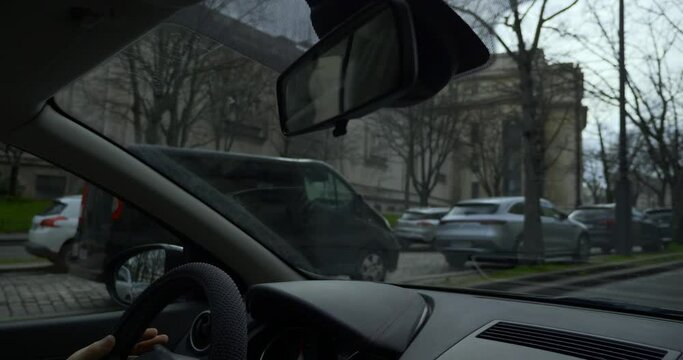 Man Driving Car Along City Street.Traffic Vehicle Cars and People. Paris France Europe Winter Spring