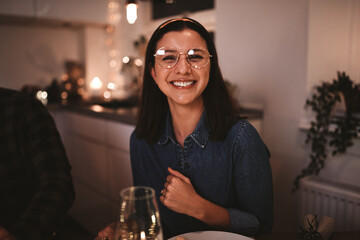 Young woman laughing during a dinner party with friends