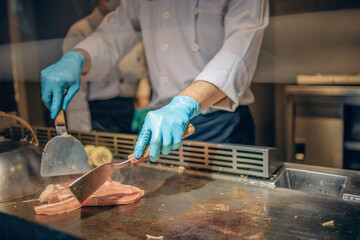Hand of man take cooking of meat with vegetable grill, Chef cooking wagyu beef in Japanese teppanyaki restaurant