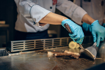 Hand of man take cooking of meat with vegetable grill, Chef cooking wagyu beef in Japanese teppanyaki restaurant