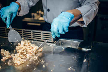 Hand of man take cooking of meat with vegetable grill, Chef cooking wagyu beef in Japanese teppanyaki restaurant