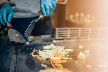 Hand of man take cooking of meat with vegetable grill, Chef cooking wagyu beef in Japanese teppanyaki restaurant