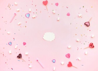 Valentines day flat lay composition.Top view sweet decor,greeting card and candle hearts on pastel pink background. Minimal style. Love, romance concept.