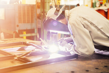 Industrial worker in manufacturing plant grinding to finish a Metal pipe,Industrial Worker at the factory welding closeup