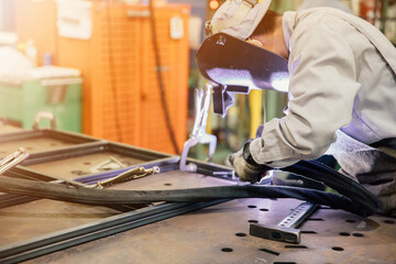 Industrial worker in manufacturing plant grinding to finish a Metal pipe,Industrial Worker at the factory welding closeup