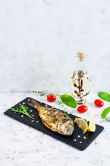 Grilled dorado fish on white background. Roasted seafish with spice and herbs