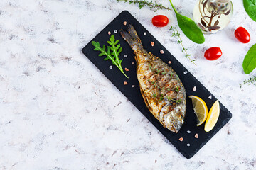 Grilled dorado fish on white background. Roasted seafish with spice and herbs