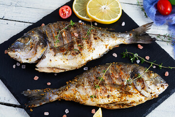 Grilled dorado fish on white background. Roasted seafish with spice and herbs