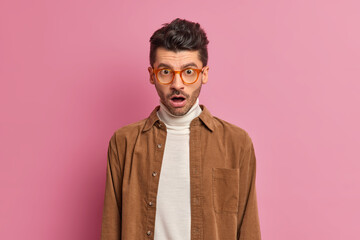 Speechless unshaven man looks in stupor drops jaw from astonishment cannot believe in shocking...