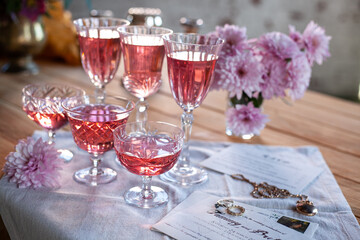 crystal glasses with rose wine, flowers on a wooden table. Wedding decoration