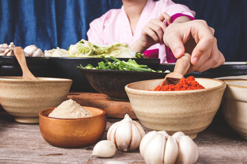 Woman hand holding a wooden spoon to scoop up chili powder Is an ingredient for cooking kimchi. The concept of Korean fermented cooking.