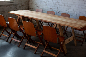Long empty wooden table and chairs for meeting up in room