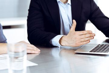 Business people using laptop computer while working together at the desk in modern office. Unknown businessman or male entrepreneur with colleague at workplace. Teamwork and partnership concept