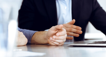 Obraz premium Business people using laptop computer while working together at the desk in modern office. Unknown businessman or male entrepreneur with colleague at workplace. Teamwork and partnership concept