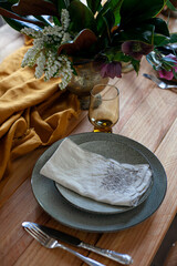 gray ceramic plates with forks, knife and napkin on festive wooden table