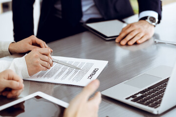 Business people discussing contract working together at meeting in modern office. Unknown businessman and woman with colleagues or lawyers at negotiation