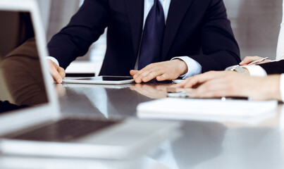 Business people working together at meeting in a modern office. Unknown businessman and woman with colleagues or lawyers at negotiation about contract