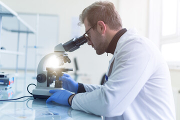 Scientist holding test tube or microscope in lab, finding treatment or vaccine for coronavirus infection. Covid-19, laboratory, and vaccine concept