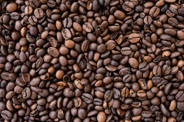 Flat lay with copy space, close-up view of some roasted coffee beans forming a natural pattern. Natural background.