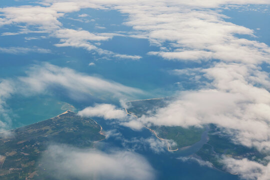 Aerial view from plane of cloud over island and sea