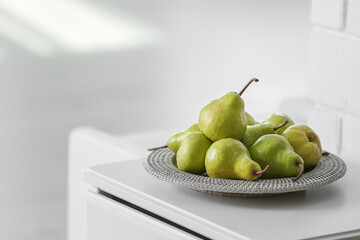Fresh ripe pears on white table in room. Space for text