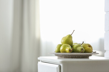 Fresh ripe pears on white table in room. Space for text