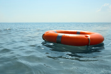 Orange life buoy floating in sea. Emergency rescue equipment