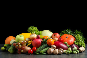 Assortment of fresh organic fruits and vegetables on grey table