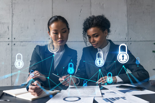 Two businesswomen work together in modern office on new project. Double exposure. Concept of success. Security lock icon.