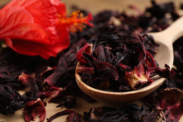 Wooden spoon with dry hibiscus tea on table, closeup © New Africa