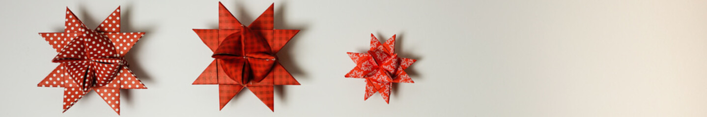 panorama christmas origami star, froebel star in red with dark background 