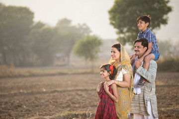Happy rural Indian family on agricultural field