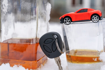 car key and a glass of whiskey in the snow