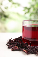 Fresh Hibiscus tea on white table against blurred background, closeup. Space for text