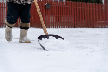 a man with a shovel cleans snow