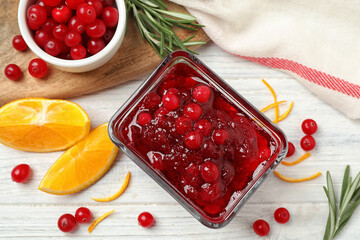 Flat lay composition with cranberry sauce and orange on white wooden table