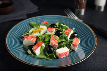 Delicious crab stick salad served on black table