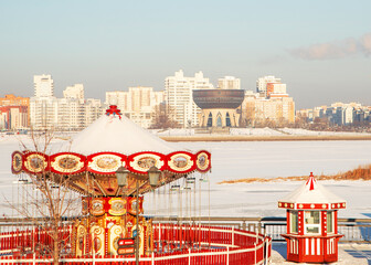 .Beautiful winter view of the city, embankment and carousel