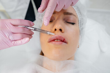 Cosmetology procedure for lip augmentation and wrinkle removal for a young beautiful girl. Cosmetology