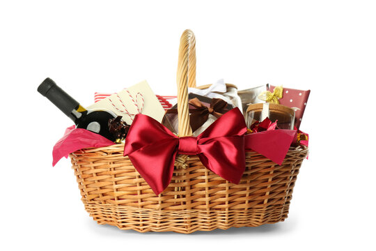 Wicker basket full of gifts isolated on white