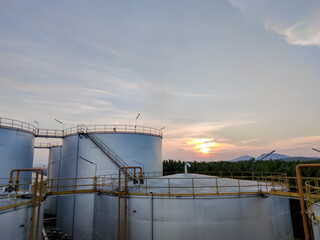 Obraz premium Crude oil export factory industry And oil storage tank. Oil storage plant from industry zone Aerial view. Factory industrial atmosphere sunset 