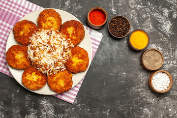 top view tasty fried cutlets with rice and seasonings on a dark background food meat rissole