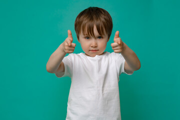 beautiful boy of five years old in a white T-shirt shows hand gestures and emotions on an isolated Copy space background