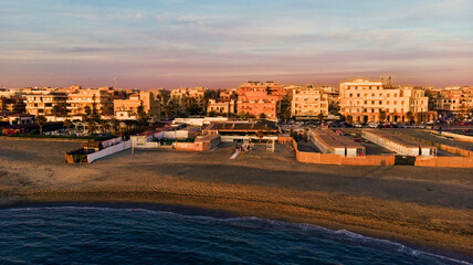 Sunset Rome aerial view in Ostia Lido beach over blue satin sea and brown sand beach, beautiful coast line and promenade a landmark of tourist and city life