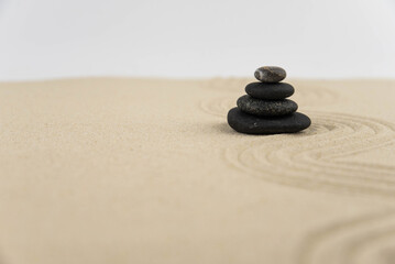 Fototapeta na wymiar Zen sand garden meditation stone background with copy space. Stones and lines drawing in sand for relaxation. Concept of harmony, balance and meditation, spa, massage, relax. Set Sail Champagne color